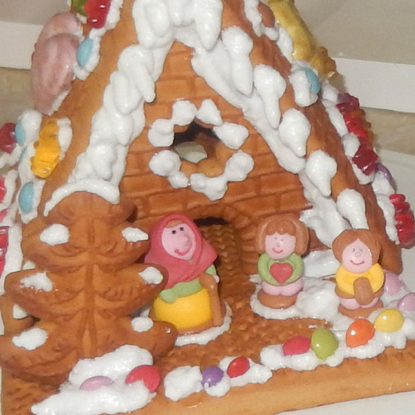 Weihnachtsbäckerei, ein Pfefferkuchenhaus mit zuckerguss und Hexe und zwei zuckerguss Kindern